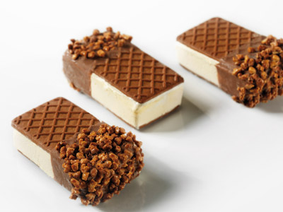Keks mit Vanille- und Sauerkirschen-Expresseis, mit Milchschokolade und Schoko-Walnussgranulat überzogen.